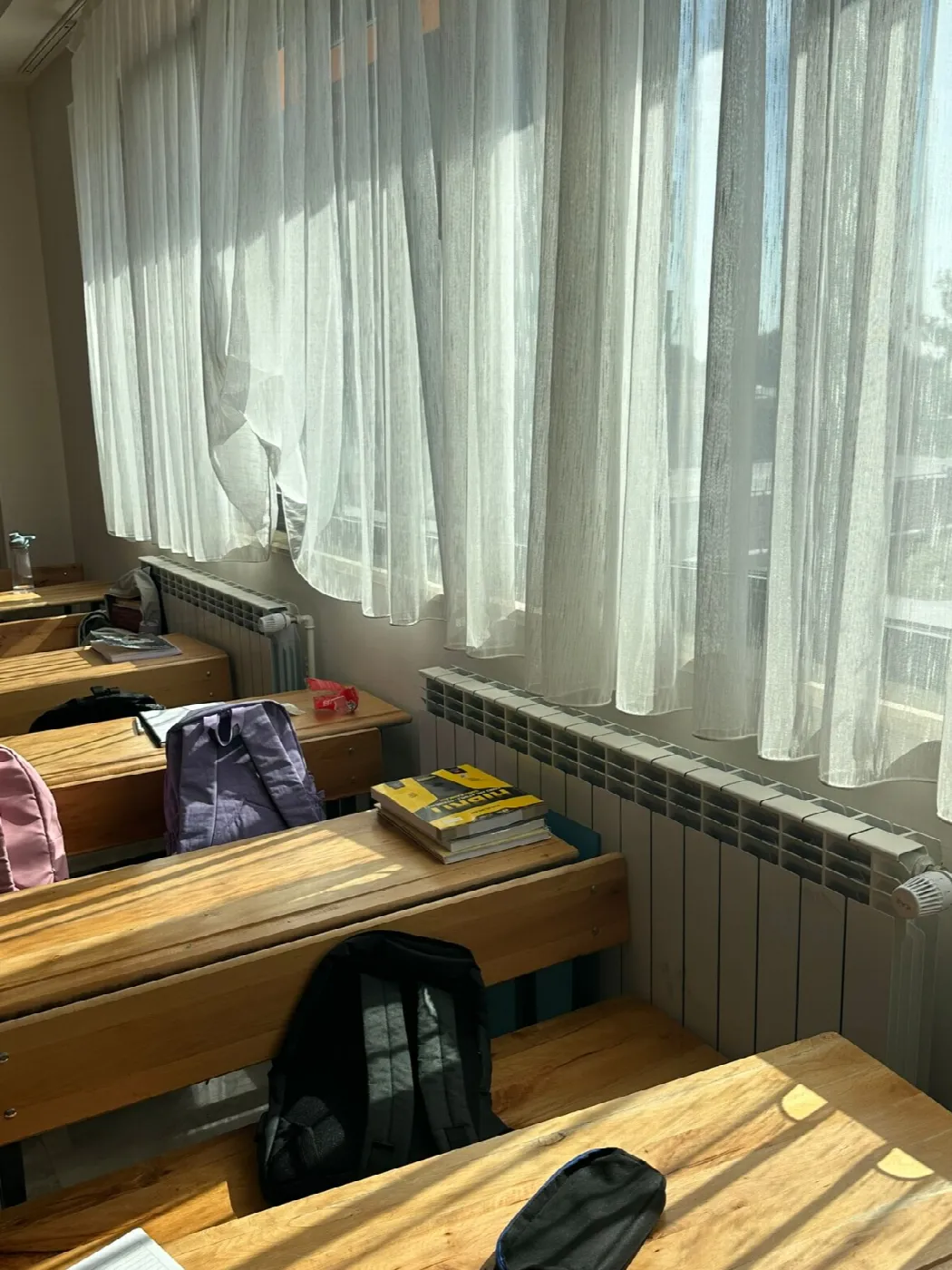 Pencere altında perde arkasında radyatör grubu