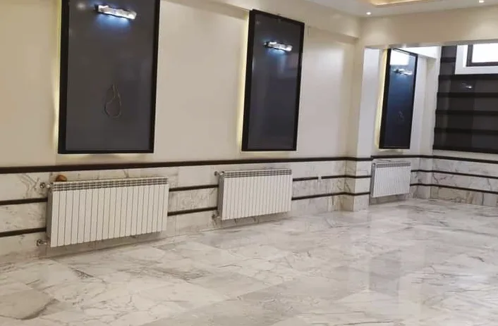 Mermer zeminli salonda pencere altına takılmış yeni alüminyum radyatörler